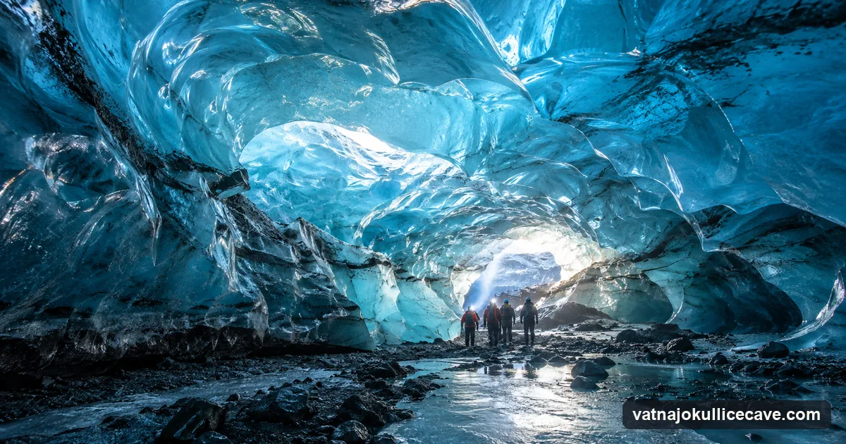 Inside an ice cave with a smooth blue ice ceiling, daylight glowing through the ice, a small group with headlamps